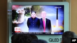 在首尔火车站，人们观看关于特朗普和金正恩的电视新闻（资料图）