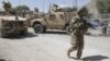 A US soldier, part of the NATO forces, patrols a police station after it was attacked by militants in Kandahar, south of Kabul, Afghanistan, June 19, 2012.