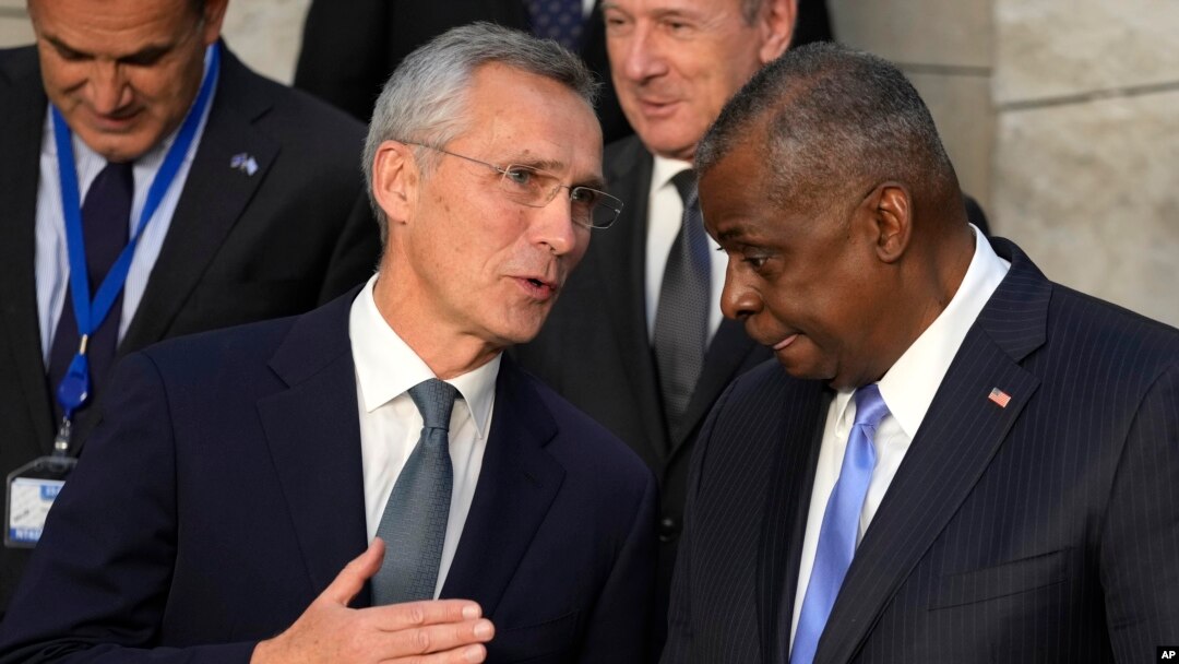 NATO Secretary General Jens Stoltenberg, left, speaks with U.S. Defense Secretary Lloyd Austin during a group photo of NATO defense ministers at NATO headquarters in Brussels, Oct. 21, 2021.