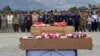 FILE - Pakistani military officials and others offer prayers for victims of a helicopter crash prior to their transport to Islamabad, at the Gilgit airport, in the Gilgit-Baltistan region of Pakistan, May 9, 2015. 