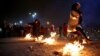 Two Iranian women jump over bonfires in the Pardisan Park in Tehran, Iran, Tuesday, March 18, 2014.