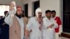 FILE - A man injured in an explosion in a Shi'ite mosque walks with relatives after receiving medical treatment at a hospital in Shikarpur, located in Pakistan's Sindh province, Jan. 30, 2015. 
