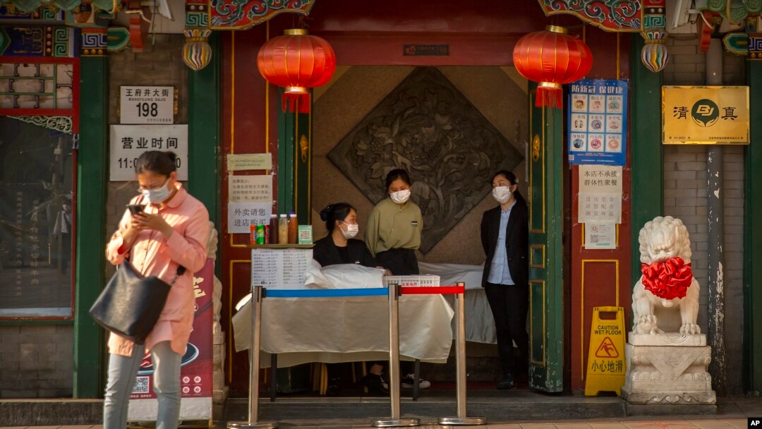 지난 4월 중국 베이징의 식당에서 점원들이 마스크를 착용한 채 손님을 기다리고 있다.