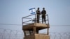 FILE - Israeli soldiers stand guard atop a watch tower along the Israel-Gaza Strip border, May 15, 2018.