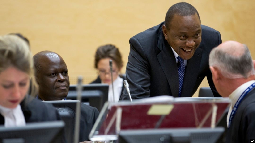 Kenya President Uhuru Kenyatta, second right, talks to his defense team when appearing before the International Criminal Court in The Hague, Netherlands, Oct. 8, 2014.