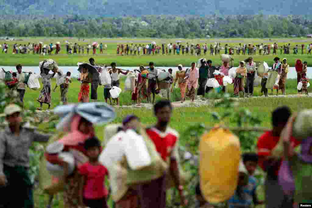 Rohingya refugees, who crossed the border from Myanmar two days before, walk after they received permission from the Bangladeshi army to continue on to the refugee camps, in Palang Khali, near Cox&#39;s Bazar, Bangladesh.