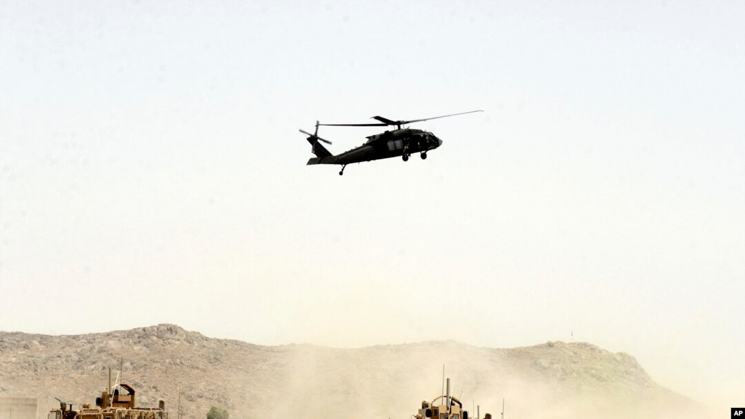 FILE - A US military helicopter flies over the site of a suicide bomb that struck a NATO convoy in Kandahar south of Kabul, Afghanistan, Aug. 2, 2017.