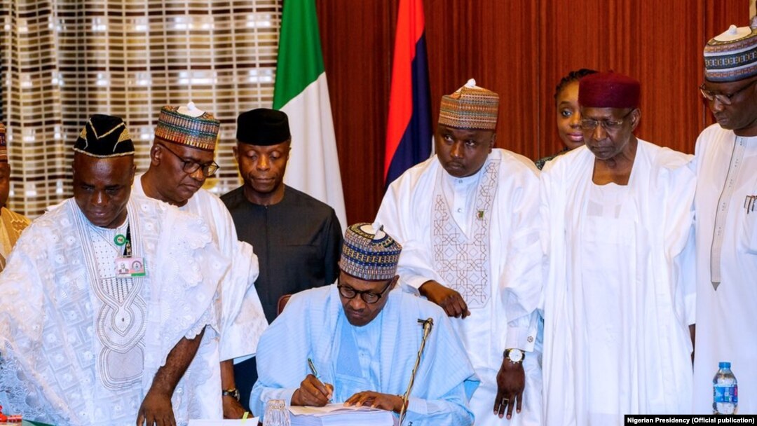 Buhari a lokacin da yake sa hannu.