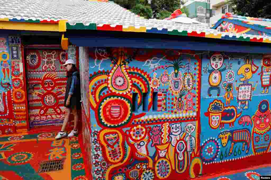 A visitor poses for a photo at rainbow village, a former military dependents&#39; village which has become a tourist attraction in Taichung, Taiwan.