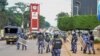 FILE - Security forces block the street leading to the Electoral Commission during a visit by Ugandan opposition presidential candidate Bobi Wine in Kampala, Uganda, Dec. 2, 2020. 