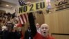 FILE - A demonstrator holds a pro-Brexit sign and a U.S. flag, as the speech by the Mayor of London, Sadiq Khan, is interrupted at the Fabian Society New Year Conference, in central London, Britain Jan. 13, 2018.