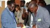 Zimbabwe's President Robert Mugabe (L) cast his vote as an election officer looks on outside Harare, July 31, 2013. 