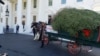 First Lady Melania Trump poses for a photo in front of the White House Christmas tree, after it arrived at the White House, Nov. 25, 2019. (Patsy Widakuswara/VOA) 