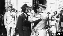 FILE - US-born singer-entertainer Joséphine Baker (C left) receives the Legion of Honor and the Croix de Guerre with palm in her Milandes Castle, Aug. 19, 1961.