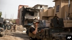FILE - An Iraqi special forces soldier speaks on the radio as troops move from the Yarmouk neighborhood to take another district from Islamic State militant control in Mosul, Iraq, April 12, 2017. 