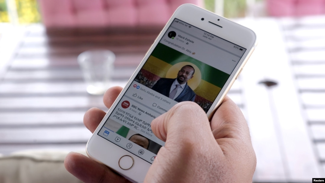 FILE - A man scrolls through his social media news feed for information about Ethiopian Prime Minister Abiy Ahmed's selection as winner of the Nobel Peace Prize in Addis Ababa, Oct. 11, 2019.
