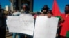 People hold banners as they stage a protest in Windhoek, Namibia, May 28, 2021.