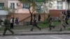 Pro-Russian armed men run near the local police headquarters in Luhansk, eastern Ukraine, April 29, 2014.