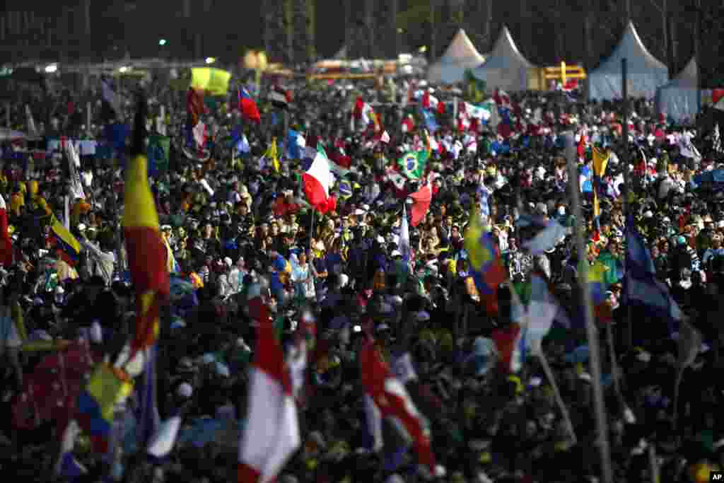Milhares de jovens se reúnem na praia de Copacabana para a missa de abertura da Jornada Mundial da Juventude no Rio de Janeiro na terça-feira.