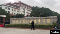 Một người đặt vòng hoa tại lối vào cổng trường Trường nghề Vô Tích tại tỉnh Giang Tô, miền đông Trung Quốc.