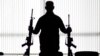 FILE - An agent of the U.S. Bureau of Alcohol, Tobacco, Firearms and Explosives holds guns at an ATF field office in Glendale, California, Aug. 9, 2017.