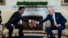 President Joe Biden, right, shakes hands with the Qatar's Emir Sheikh Tamim bin Hamad Al Thani in the Oval Office of the White House, Jan. 31, 2022, in Washington. 