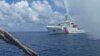 FILE - A Chinese Coast Guard vessel approaches a Filipino fishing boat off Scarborough Shoal in the South China Sea, Sept. 23, 2015.