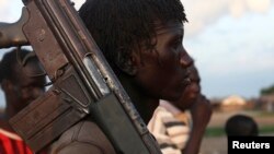 FILE - A man from the Luo Nuer tribe carries his gun in Yuai Uror county, South Sudan.