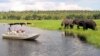 FILE - Foreign tourists in safari riverboats observe elephants along the Chobe river bank in Chobe National Park, in northern Botswana, March 2005.