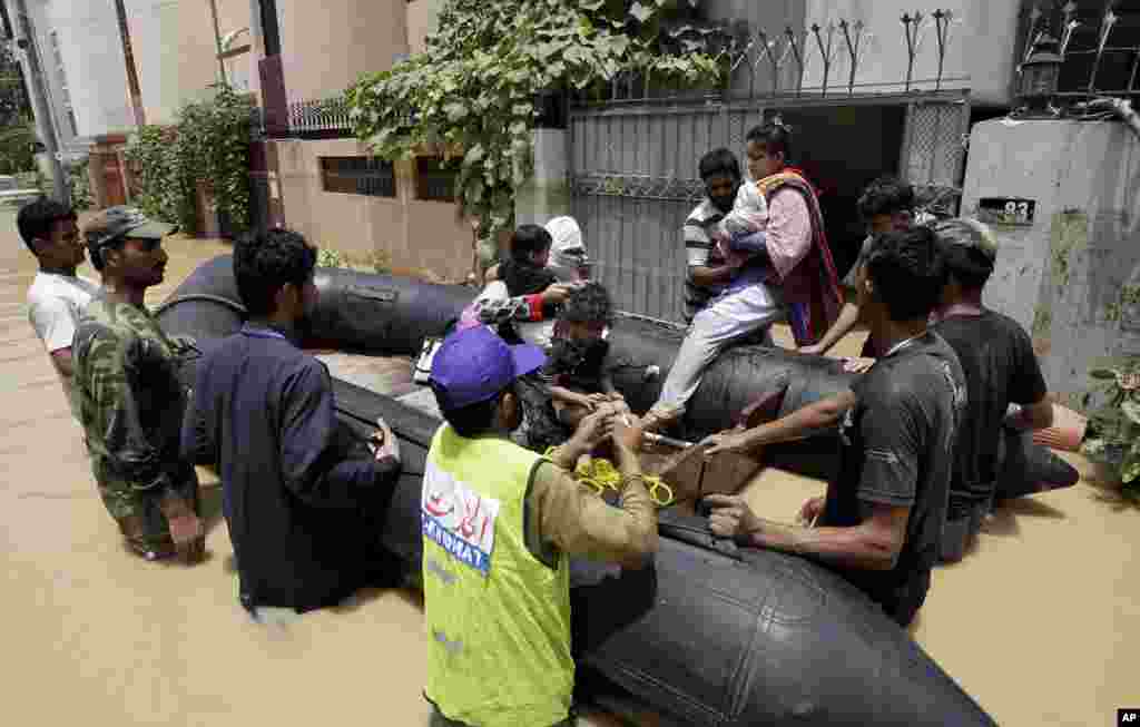 Pakistani soldiers rescue a family from an area flooded by heavy rains on the outskirts of Karachi, Pakistan, August 4, 2013. 