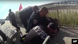 In this photo taken from police body cam video, New York Police officers arrest a man on a boardwalk in New York, June 21, 2020. 