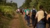 Syrian refugees walk across railway tracks next to the Serbian town of Horgos to cross the border and enter Hungary, Sept. 1, 2015.