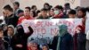 FILE - Migrants shout slogans during a protest over dire living conditions in Mytilene port, on the northeastern Aegean island of Lesbos, Greece, on Feb. 4, 2020. 