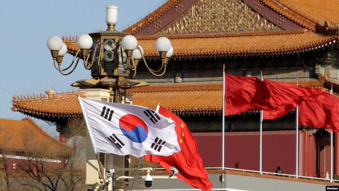 FILE - South Korea's and China's flags flutter next to Tiananmen Gate during the visit of then-South Korean President Moon Jae-in in Beijing, Dec. 15, 2017. 
