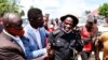 Ugandan pop star and presidential candidate Robert Kyagulanyi, also known as Bobi Wine, assists one of his bodyguards who was injured in clashes between Wine's supporters and security forces in Kayunga district near Kampala, Uganda, Dec. 1, 2020.