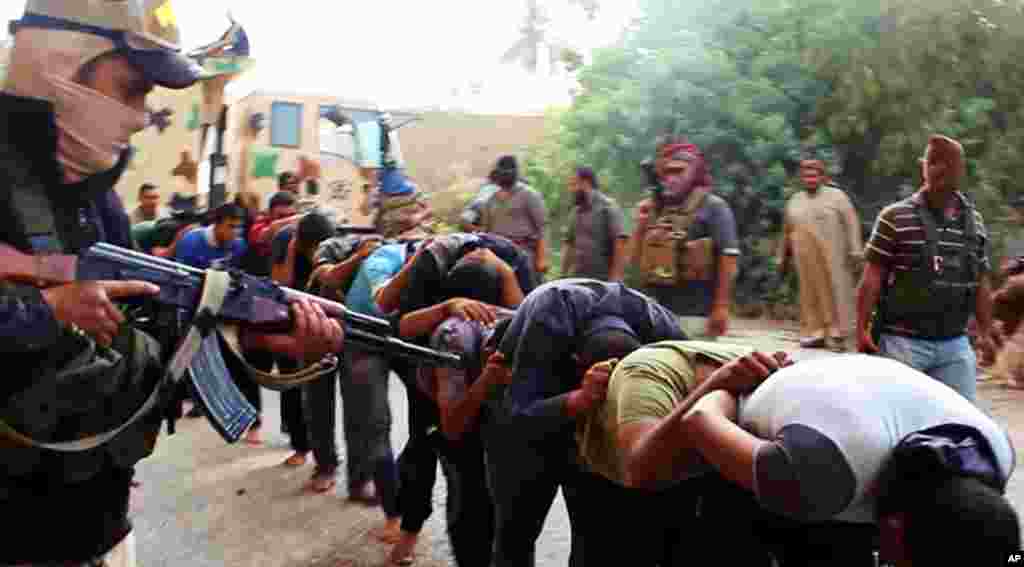 "Iroq va Shom islomiy davlati" jangarilari asirga olingan Iroq hukumati askarlari bilan, 14-iyun, Tikrit, Iroq.