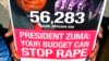 A man holds a poster during a protest against violence toward woman, before South African Finance minister Pravin Gordhan gave his budget speech at Parliament in Cape Town , South Africa, Feb. 27, 2013.