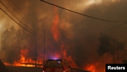 Firefighters drive through smoke from a forest fire in Chaveira, Portugal, July 22, 2019. 